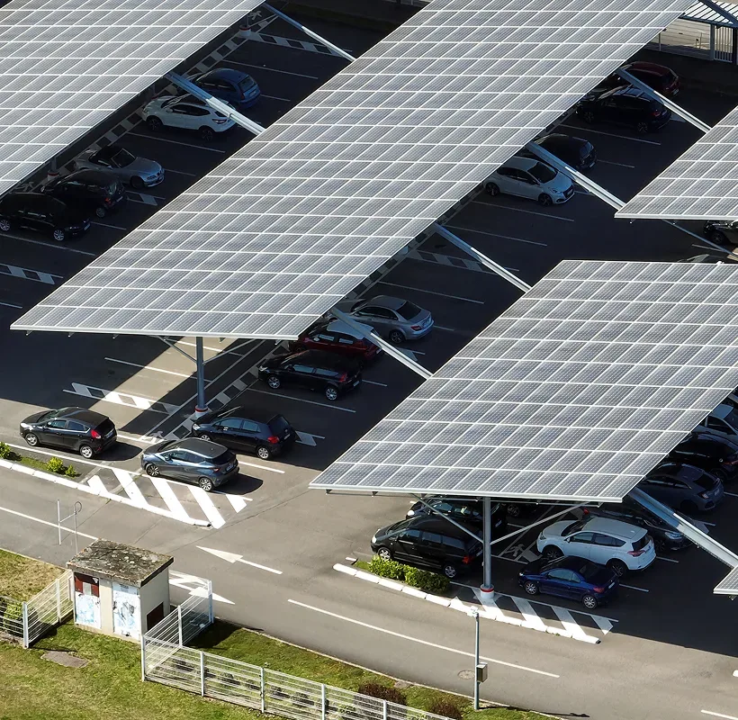 Double row solar carports covering two rows of parked cars in a commercial lot